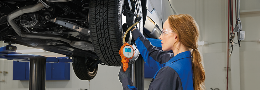 A Subaru technician checking tire pressure. | Dyer Subaru in Vero Beach FL