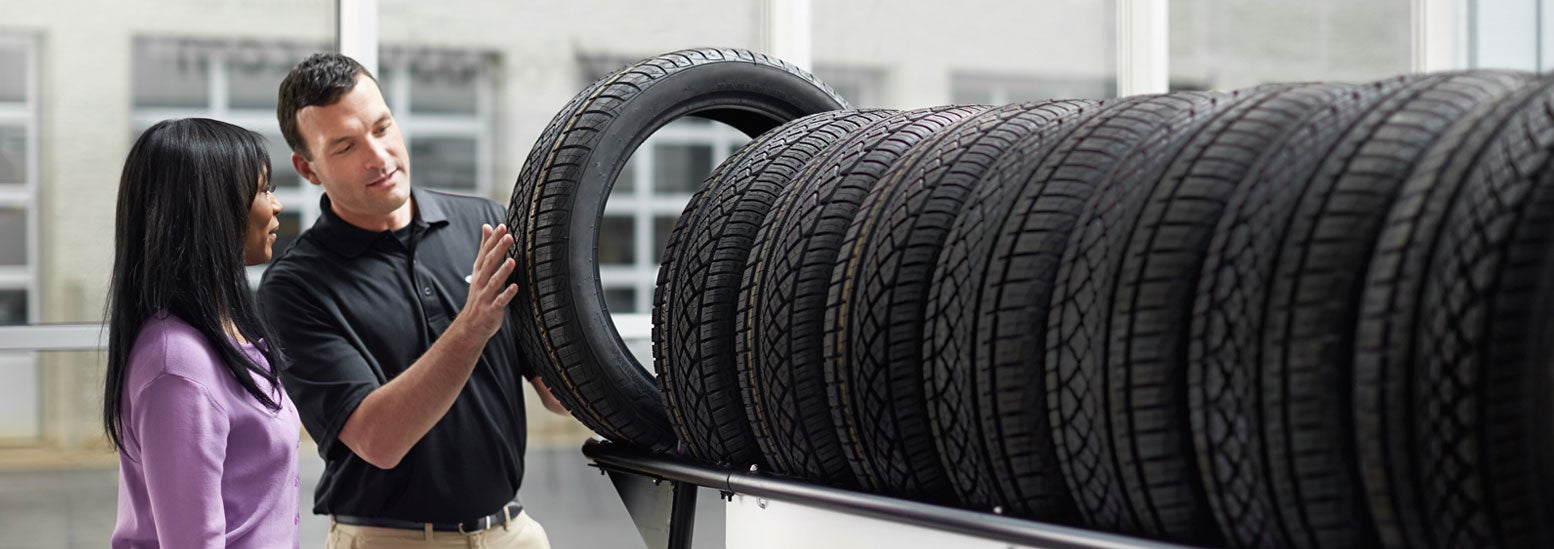 Subaru service representative showing customer a tire. | Dyer Subaru in Vero Beach FL