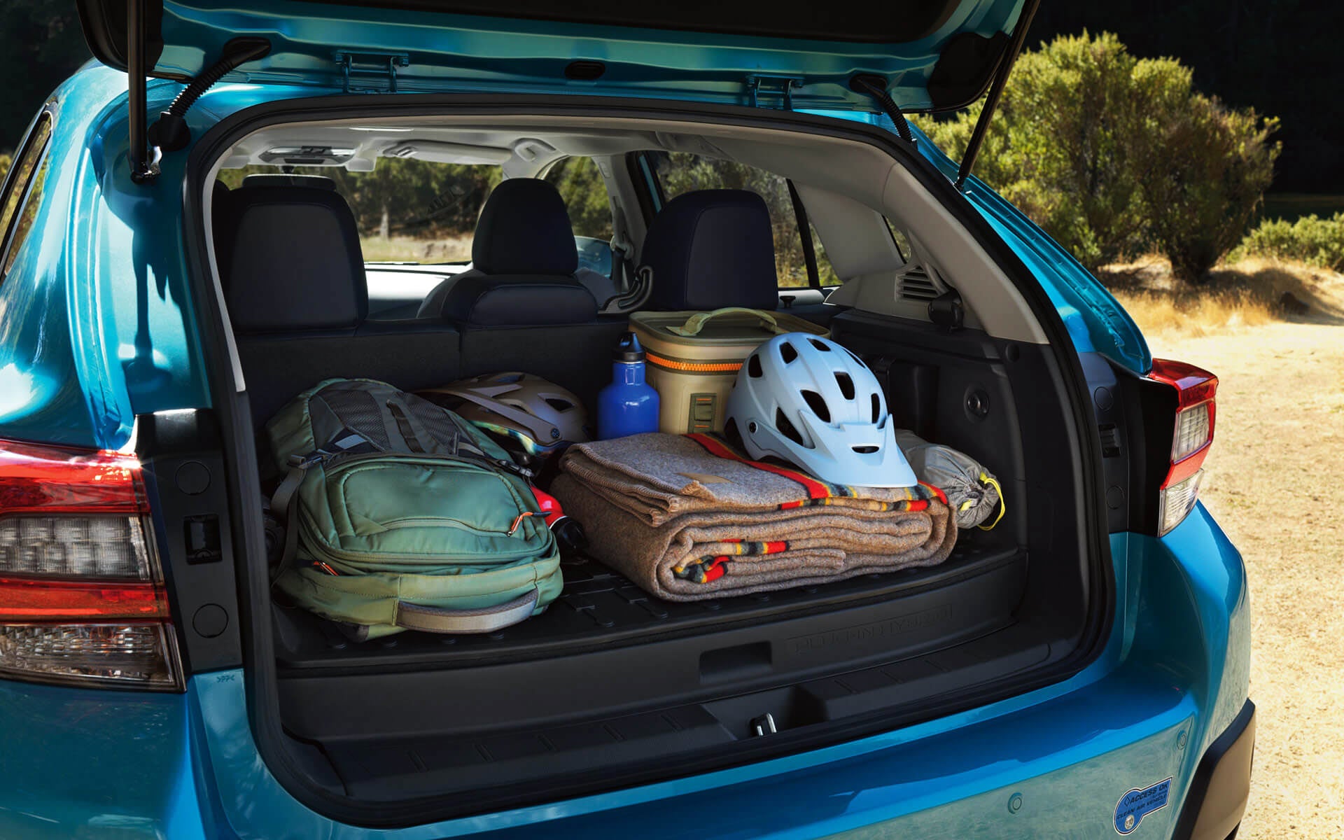 A backpack, blanket, and bike helmet in the rear cargo area of a Crosstrek Hybrid | Dyer Subaru in Vero Beach FL