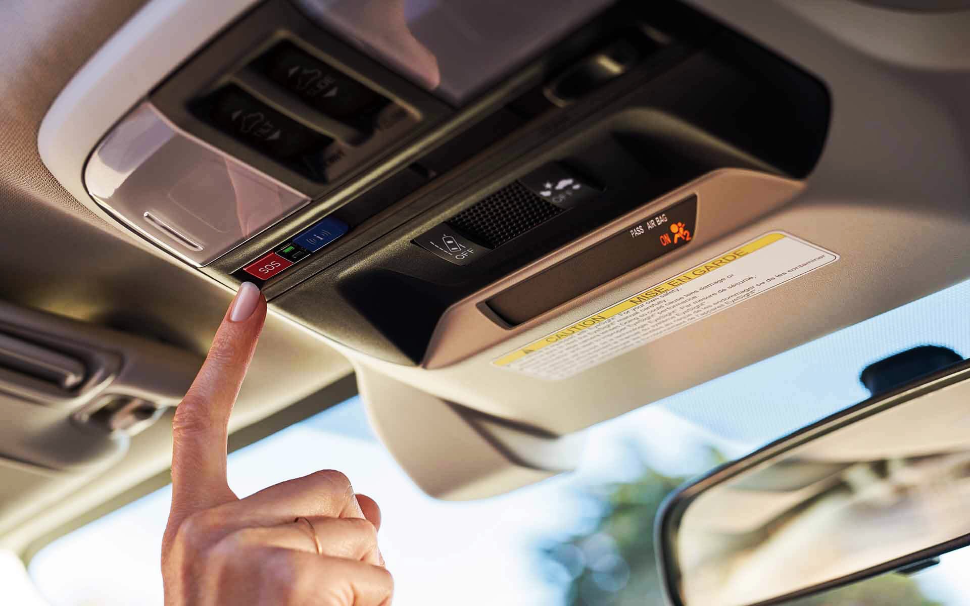 A finger pressing the Crosstrek Hybrid's SOS emergency assistance button | Dyer Subaru in Vero Beach FL
